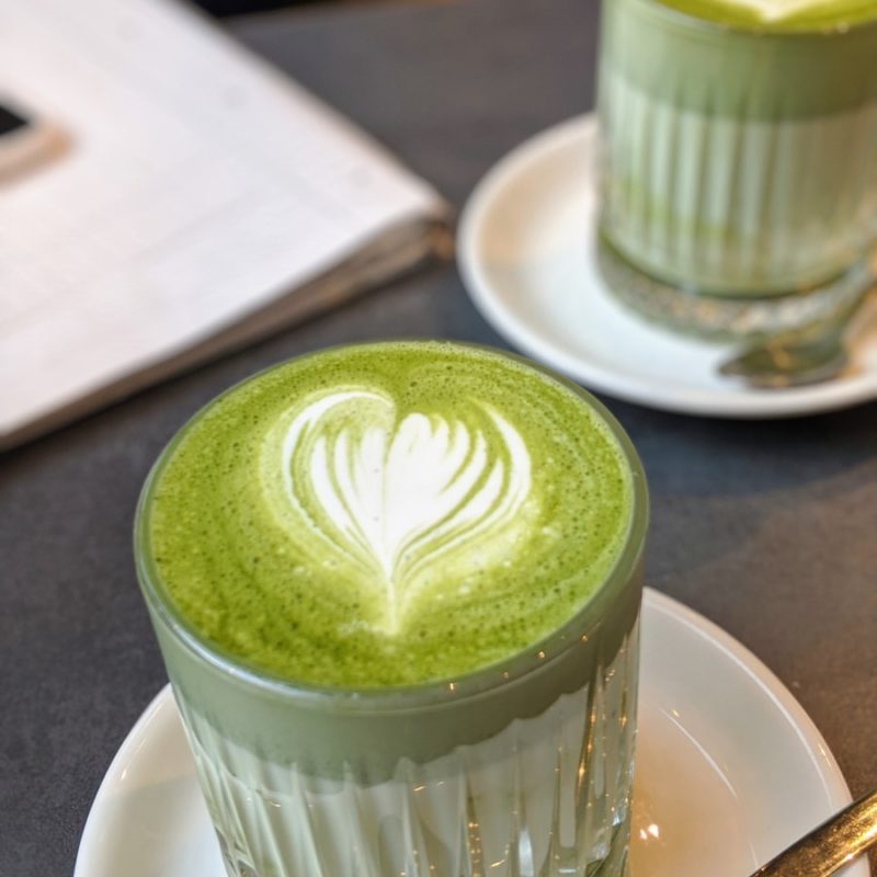 green and white floral cup on white ceramic saucer